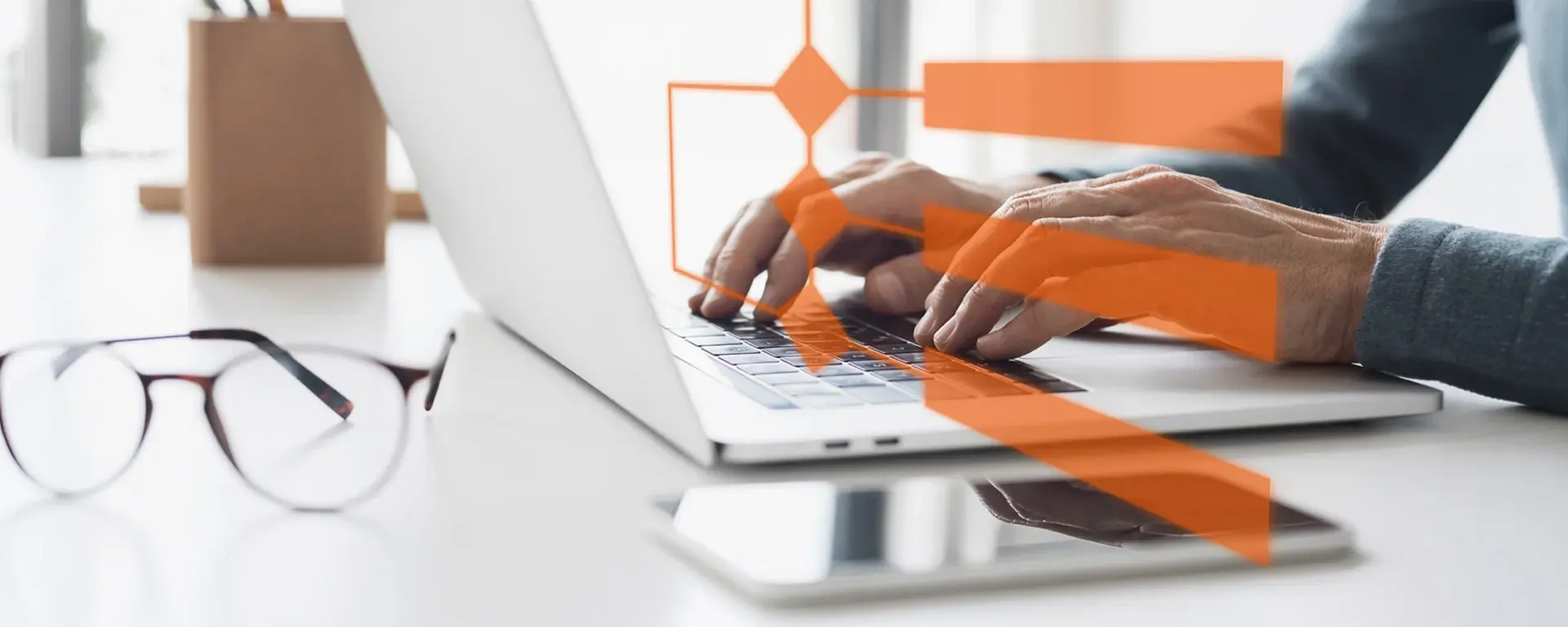 Hands using a laptop with an overlaid process diagram