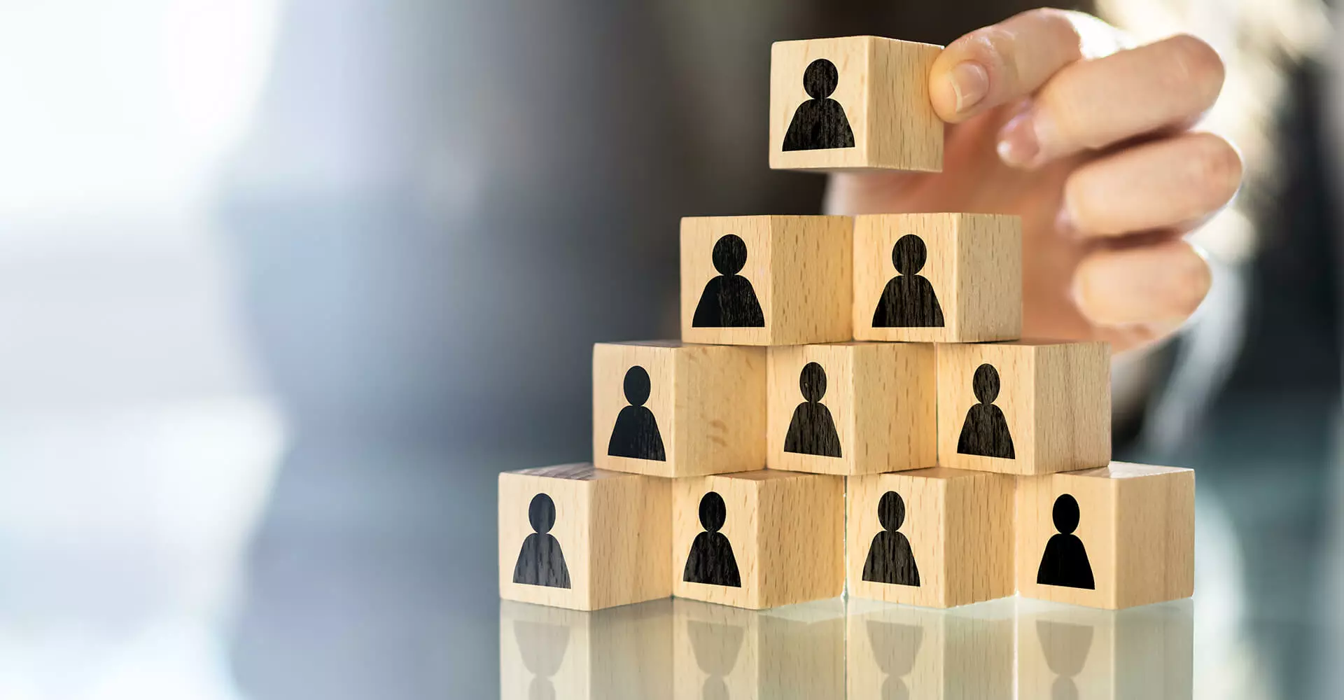 Wooden blocks stacked in a pyramid shape with people depicted on them