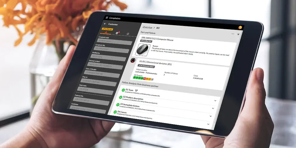 Two hands holding a tablet; on it you can see the complaint management in BabtecQ Go