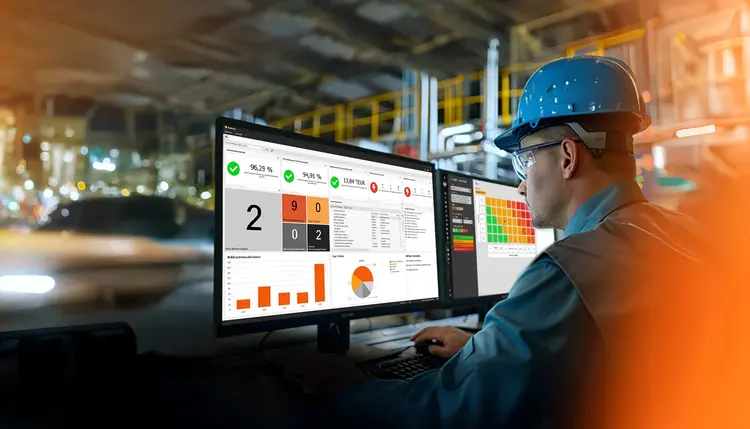 Integrated QM software In a production facility, a man looks at two screens displaying Babtec's QM software