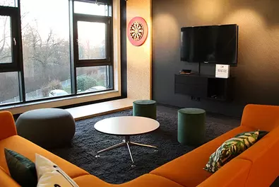 Work more beautifully at Babtec Redesigned workspace with orange sofa