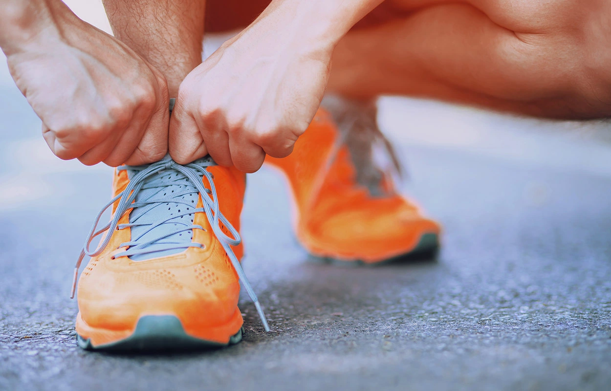 Man gets ready for the run in his orange-coloured trainers.