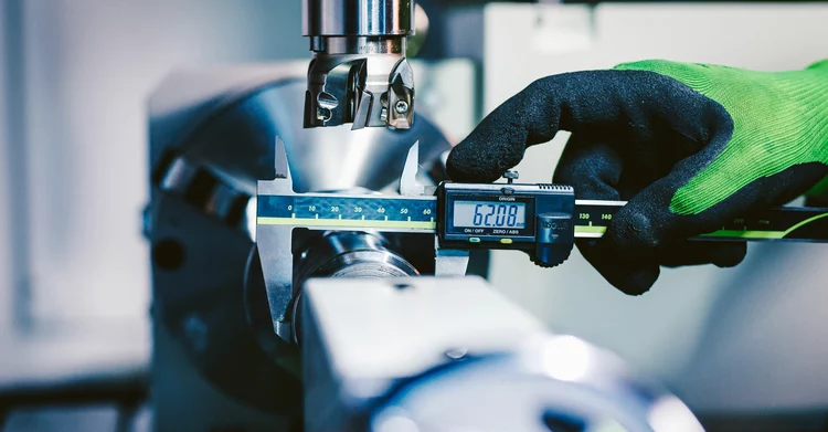 VDA Volume 5 on measuring and inspecting A person is measuring an object as part of a production inspection