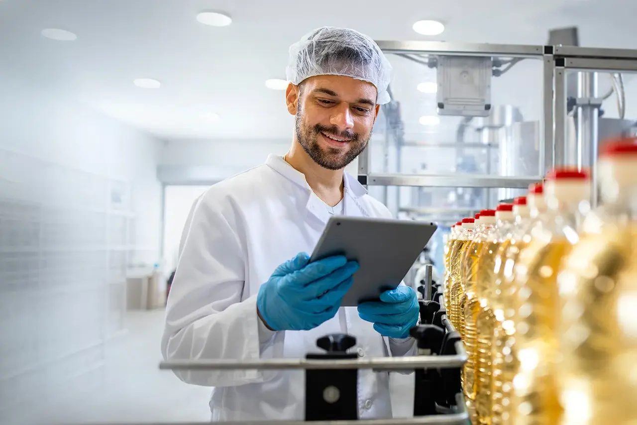 Conveyor belt in the food industry Employee with a tablet at a bottling line